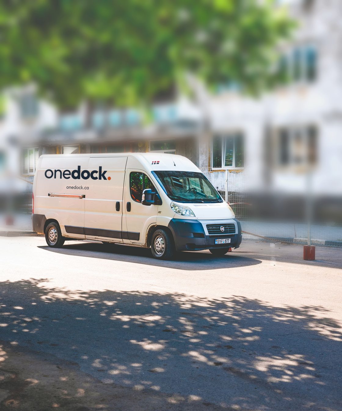 A white Onedock delivery van parked at the kerb, the wordmark and onedock.ca on its side panel.